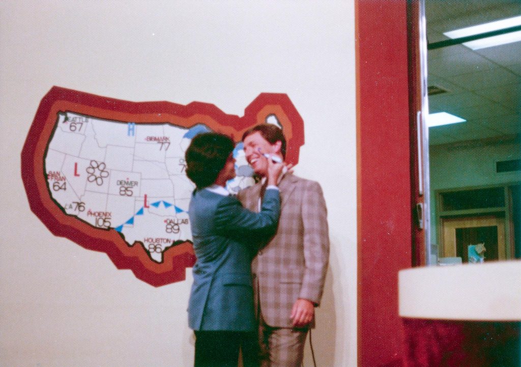 Donnie Osmond writes on Paul Orlousky's face with a marker while standing in front of a weather map.